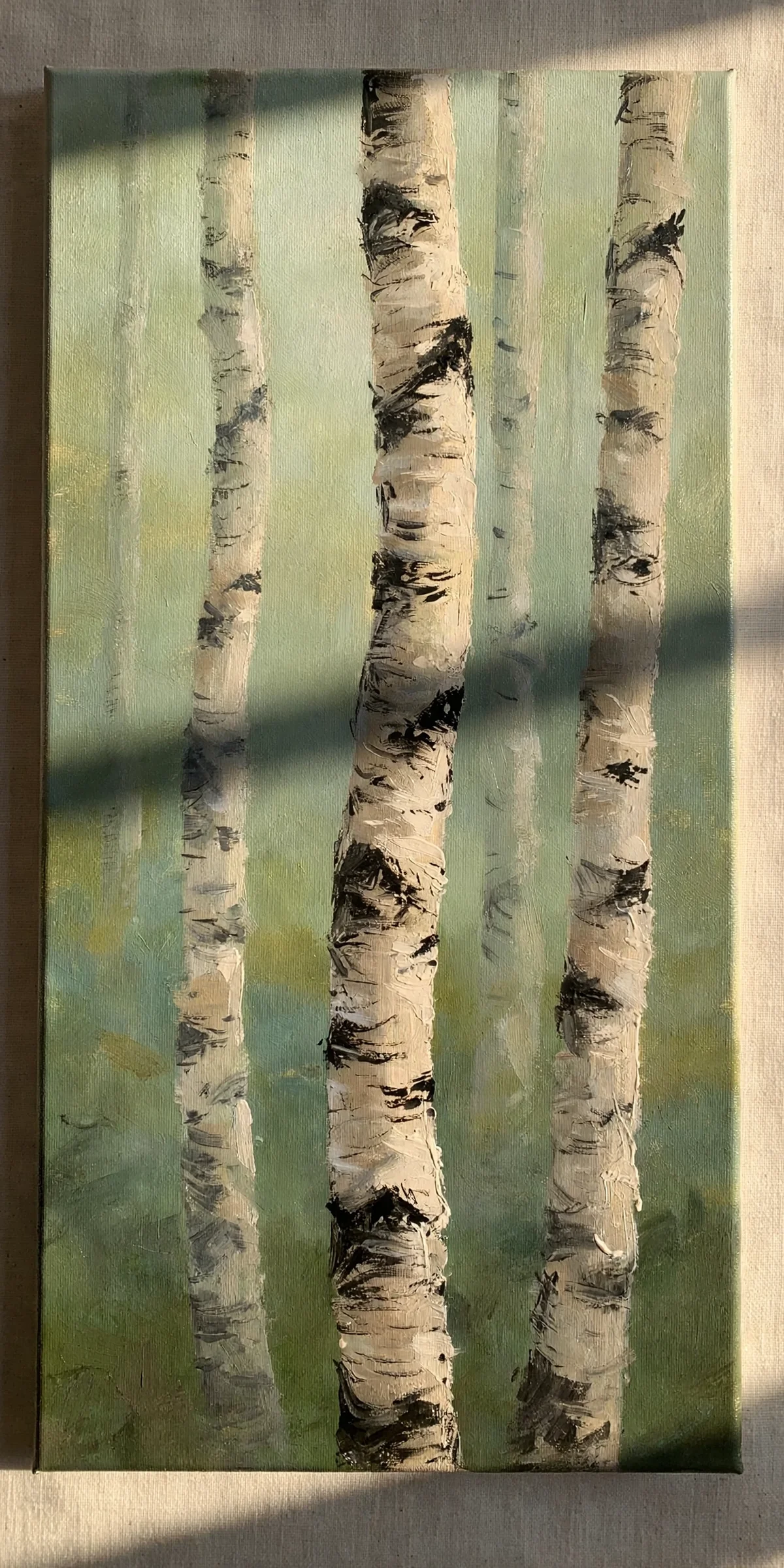 A canvas painting of birch trunks against misty sage