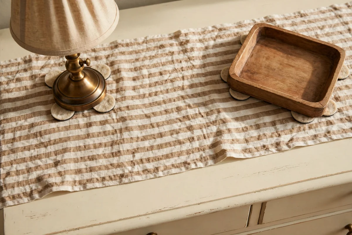 Painted dresser top with linen runner and felt padded decor
