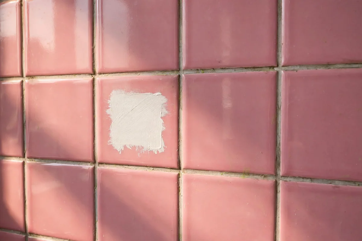 Pink tiled wall with a small test patch of tile paint beside it